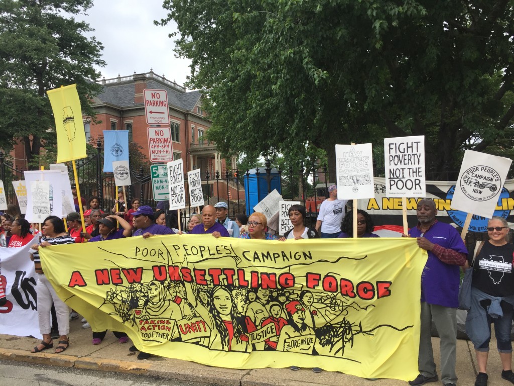 Hospital workers carry the banner as part of the Poor Peoples Campaign which marched and held a press event outside Gov. Bruce Rauner's executive mansion in Springfield, IL to call for a $15 minimum wage; June 11, 2018). 