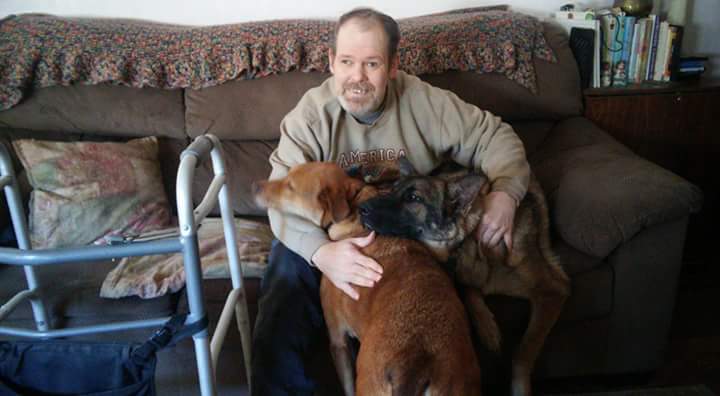 David Conn in his Peoria home with his two dogs.